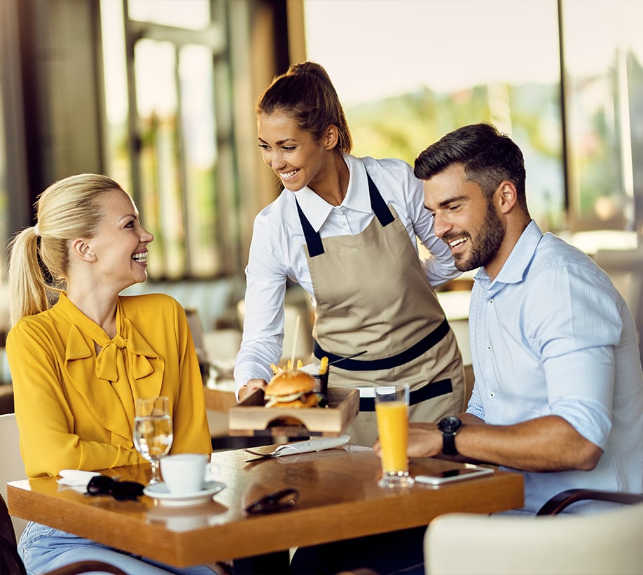Paar mit Kellnerin in Restaurant